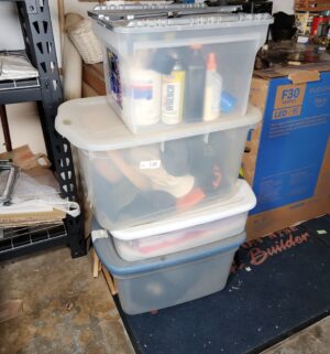 x189- storage totes w/ misc clothing, household products