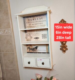 a161- distressed white wooden wall-mounted shelf unit with two drawers and decorative botanical-themed back panels