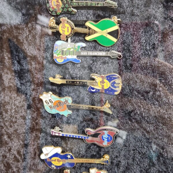 e148- large collection of Hard Rock Cafe pins arranged in the