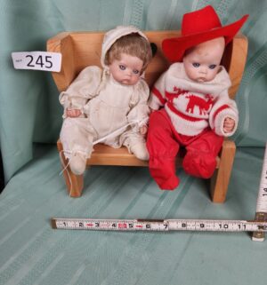 g245- 2 small dolls in a heart wooden bench