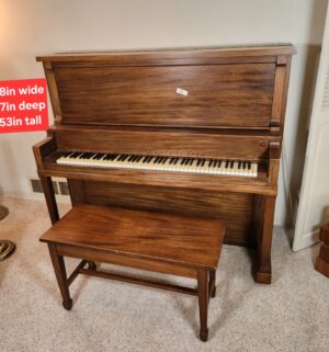 t84- Melodigrand Upright Piano w/ bench. Buyer to bring assistance to move. Moving equipment available to use.