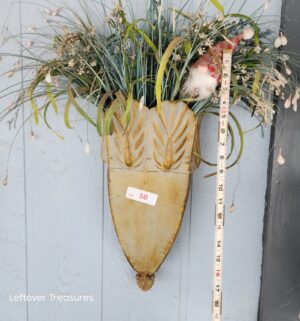 v50- rustic farmhouse-style wall-mounted planter holding artificial greenery