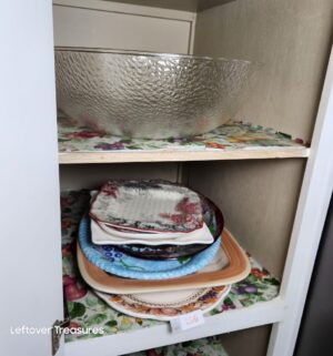 v136- server platters, plastic bowl in cabinet