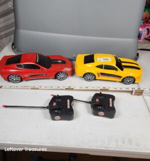 y155- New Bright 1:10 scale remote control sports cars, specifically a red Corvette and a yellow Camaro - Image 1