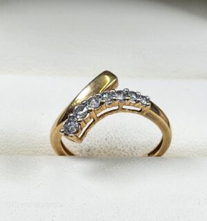 c154- 10k yellow gold bypass band featuring a channel-set row of clear diamonds. Gold/Diamonds Tested